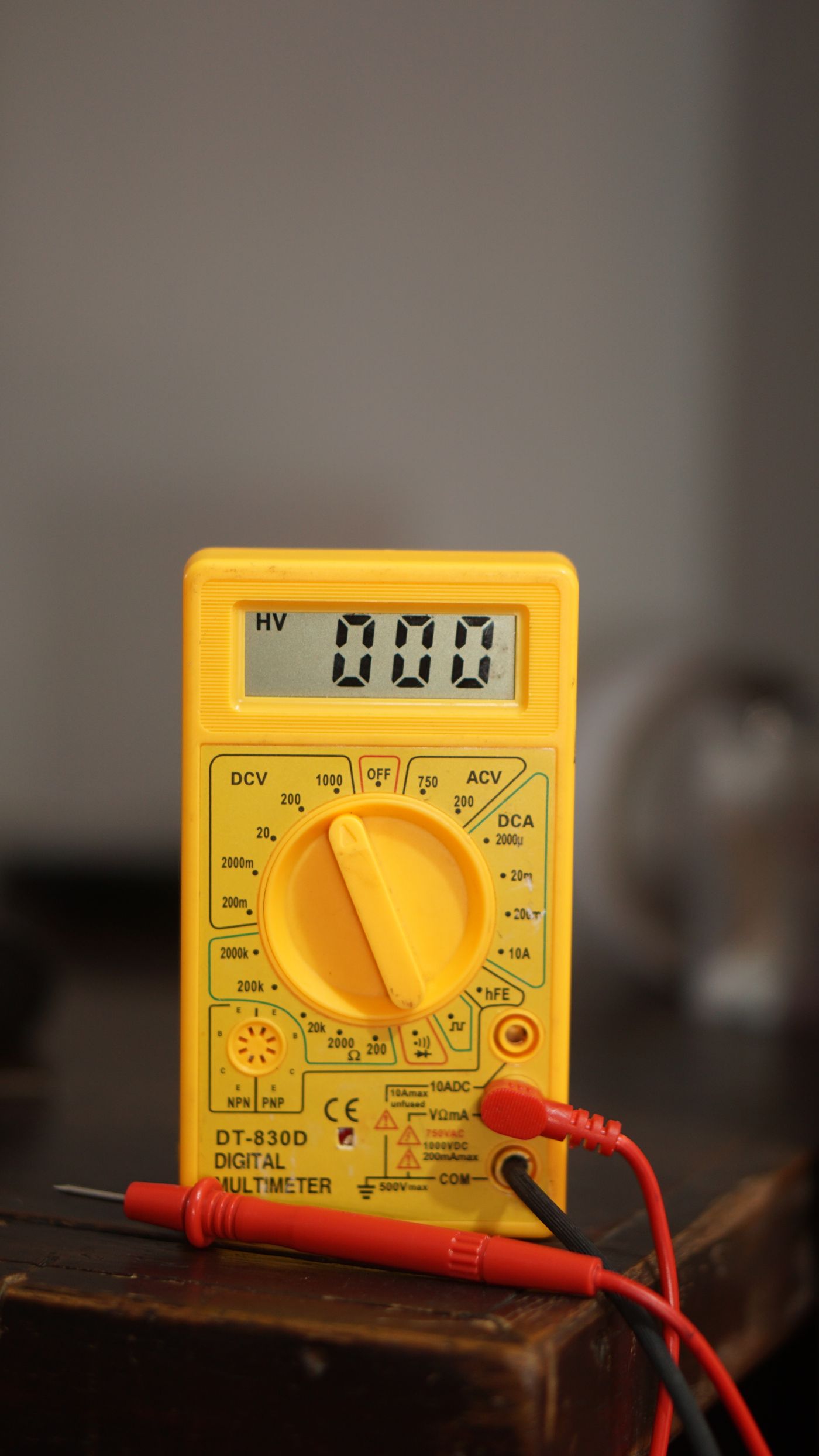 Yellow digital multimeter with red and black test leads
