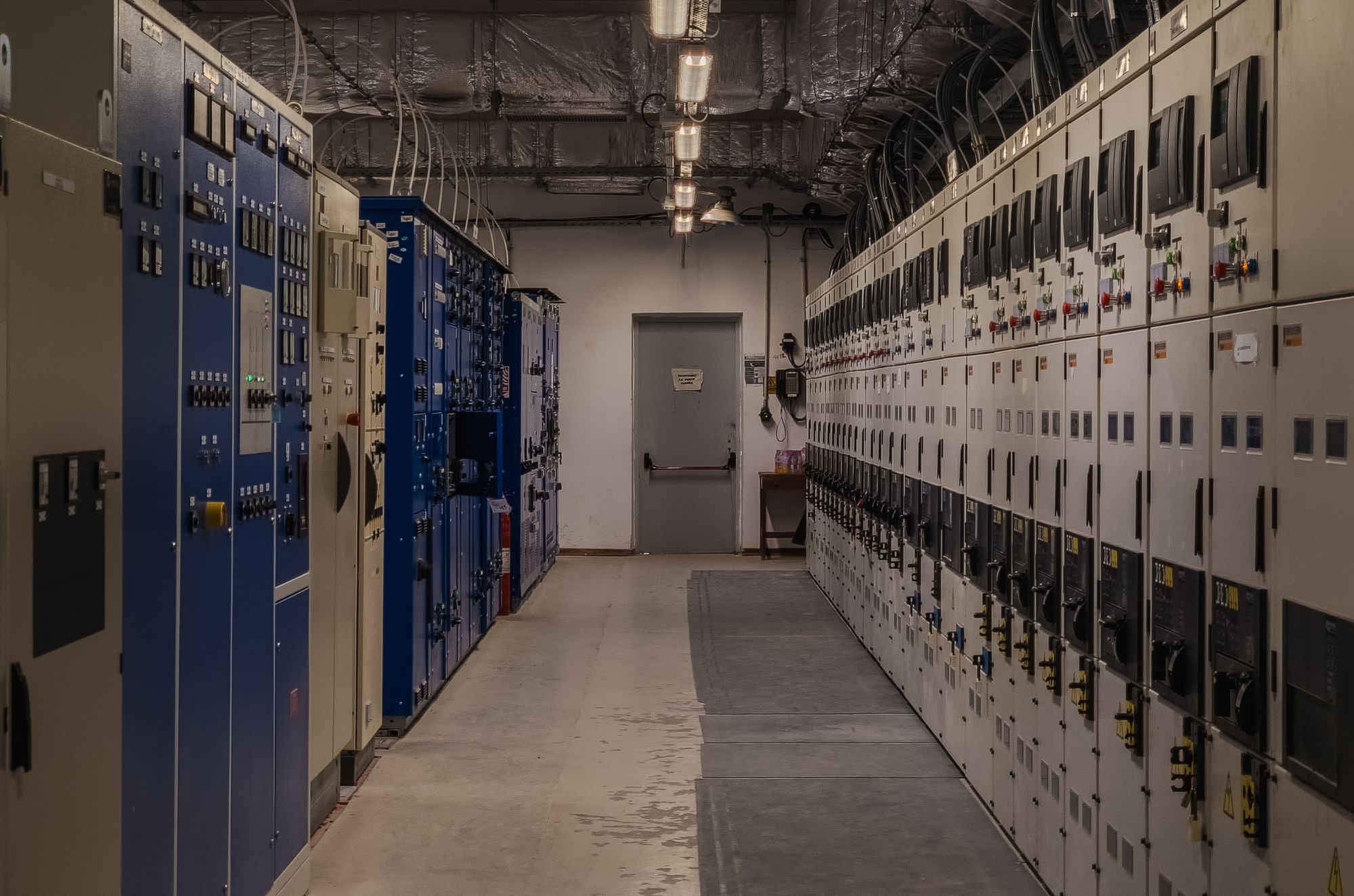 Industrial switch room lined with tall electrical control panels