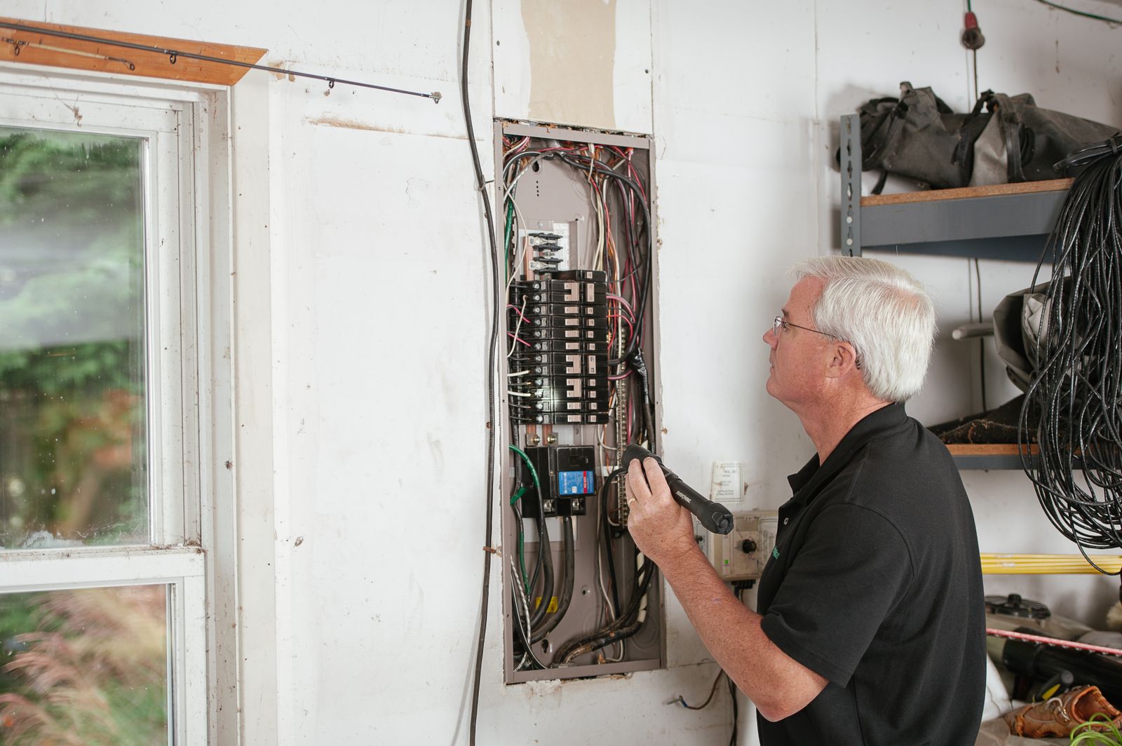 An experienced electrician inspecting a domestic fuse board